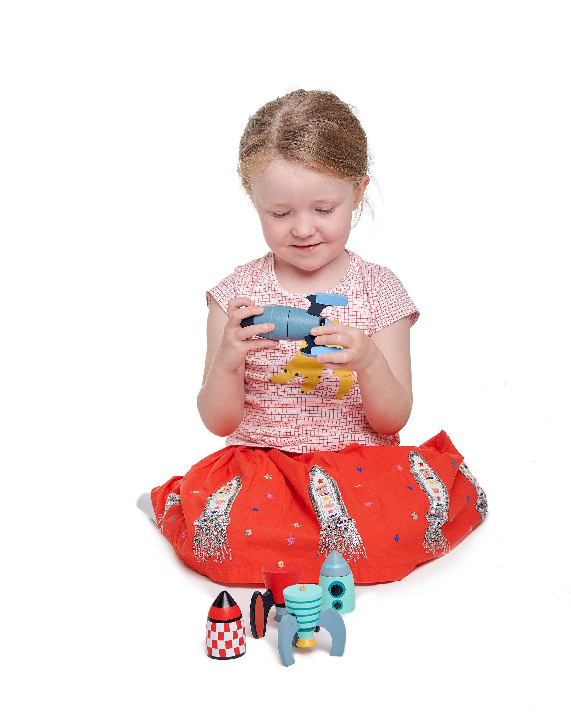 Girl constructing wooden rocket ship