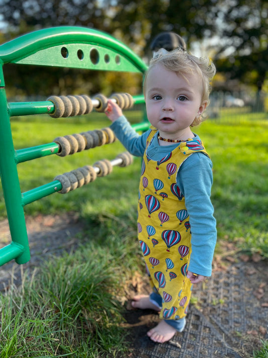 Boy wearing yellow organic hot air balloon romper