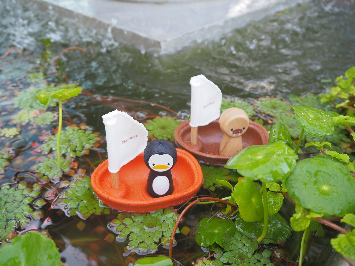 Penguin and Walrus Sailing Boat floating in a water fountain