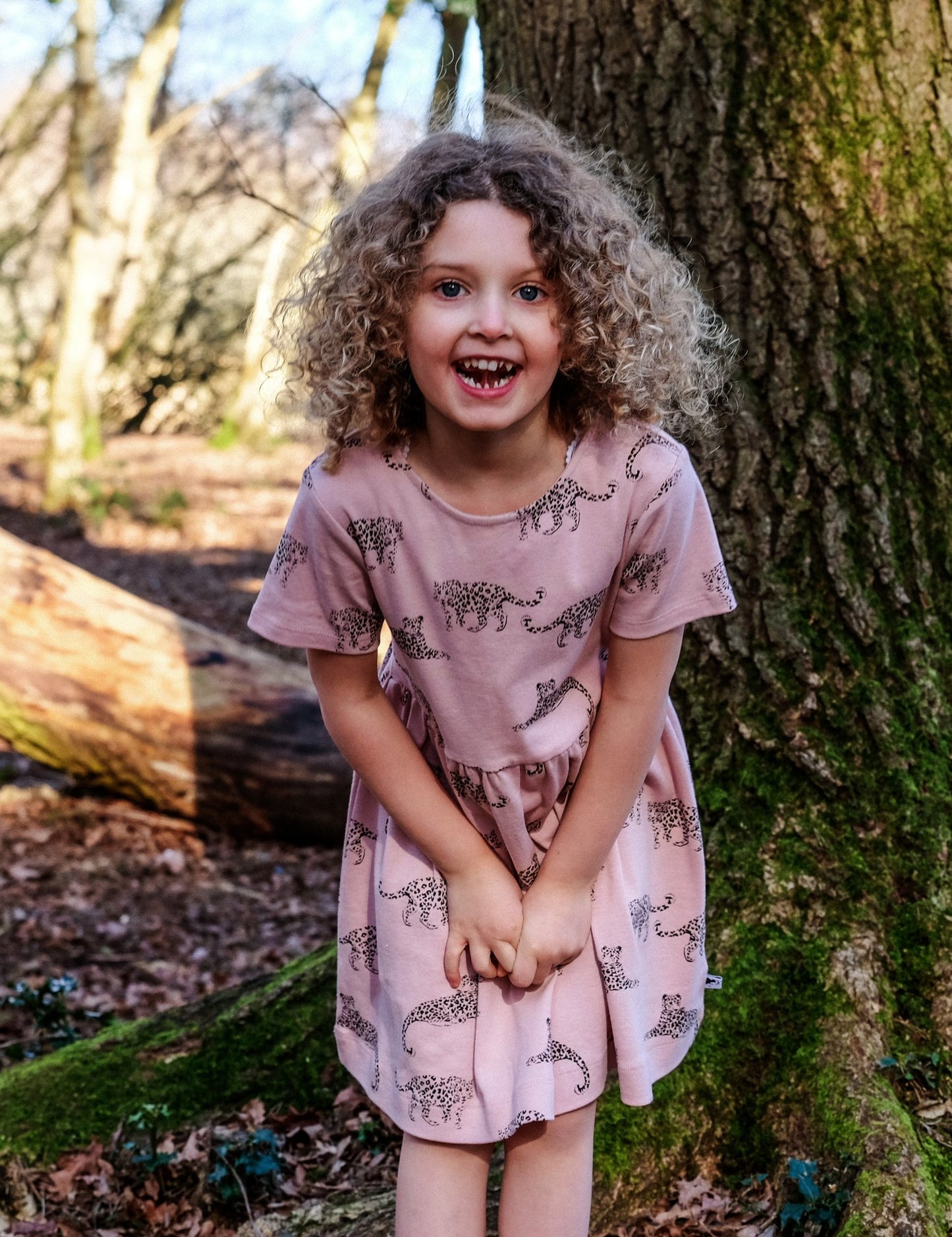 Girl wearing organic dusky pink leopard dress in the woods