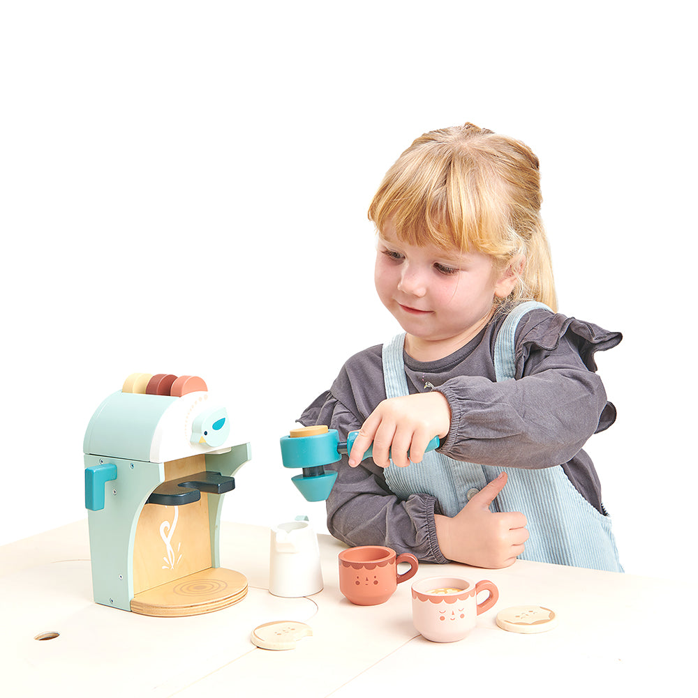 Girl playing with wooden babyccino maker set