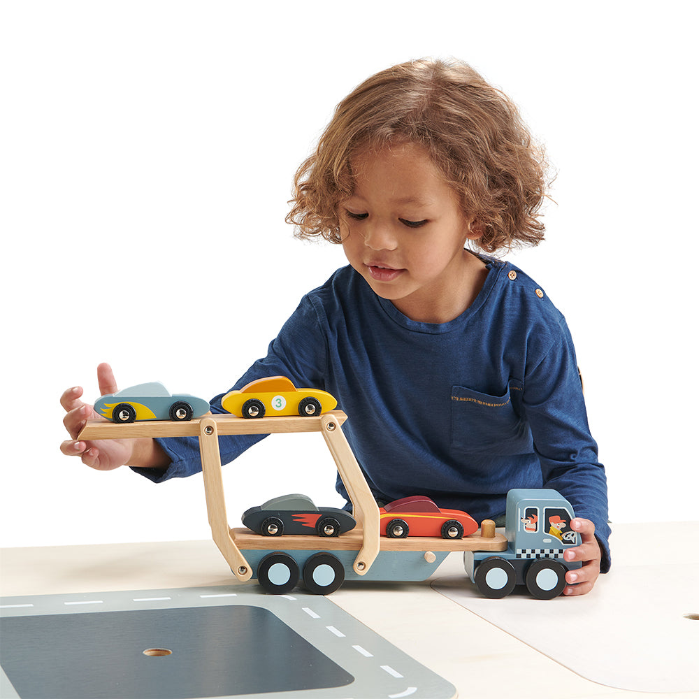 Boy playing with car transporter ramp and cars