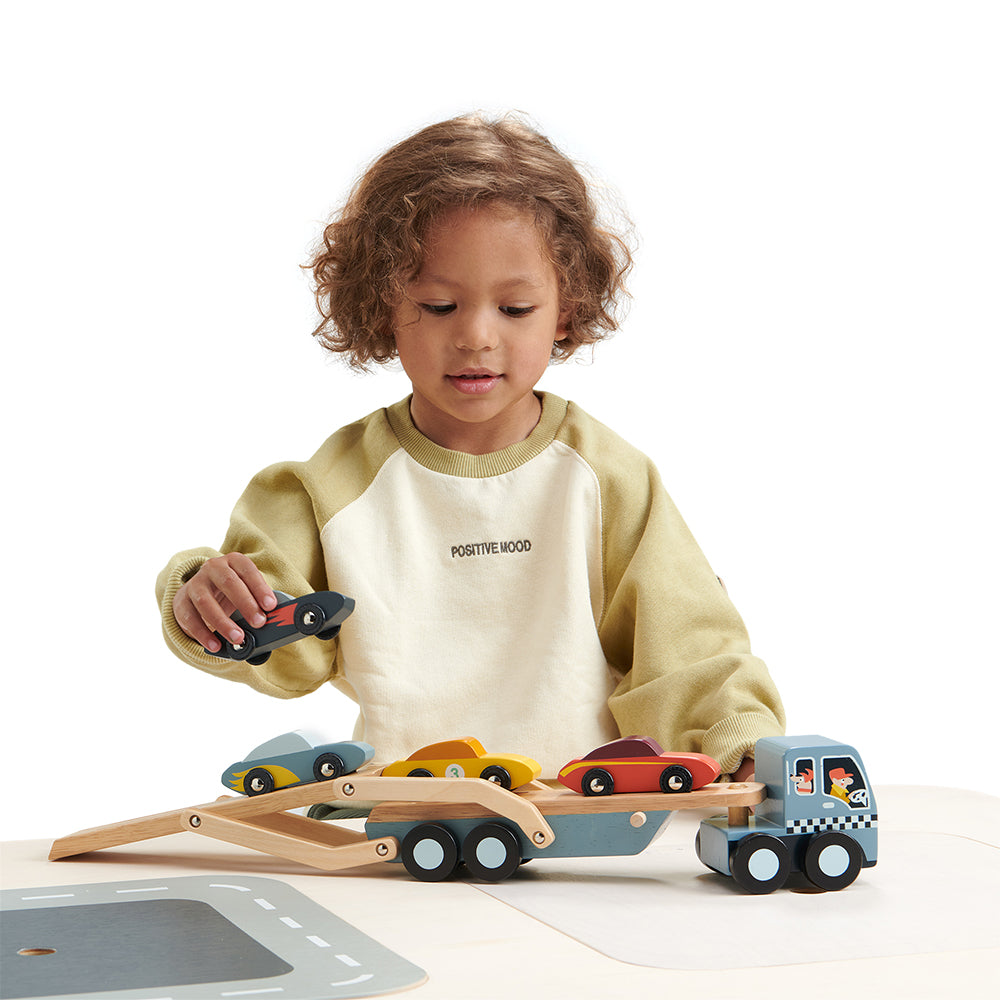 Boy playing with super stylish cars and car transporter