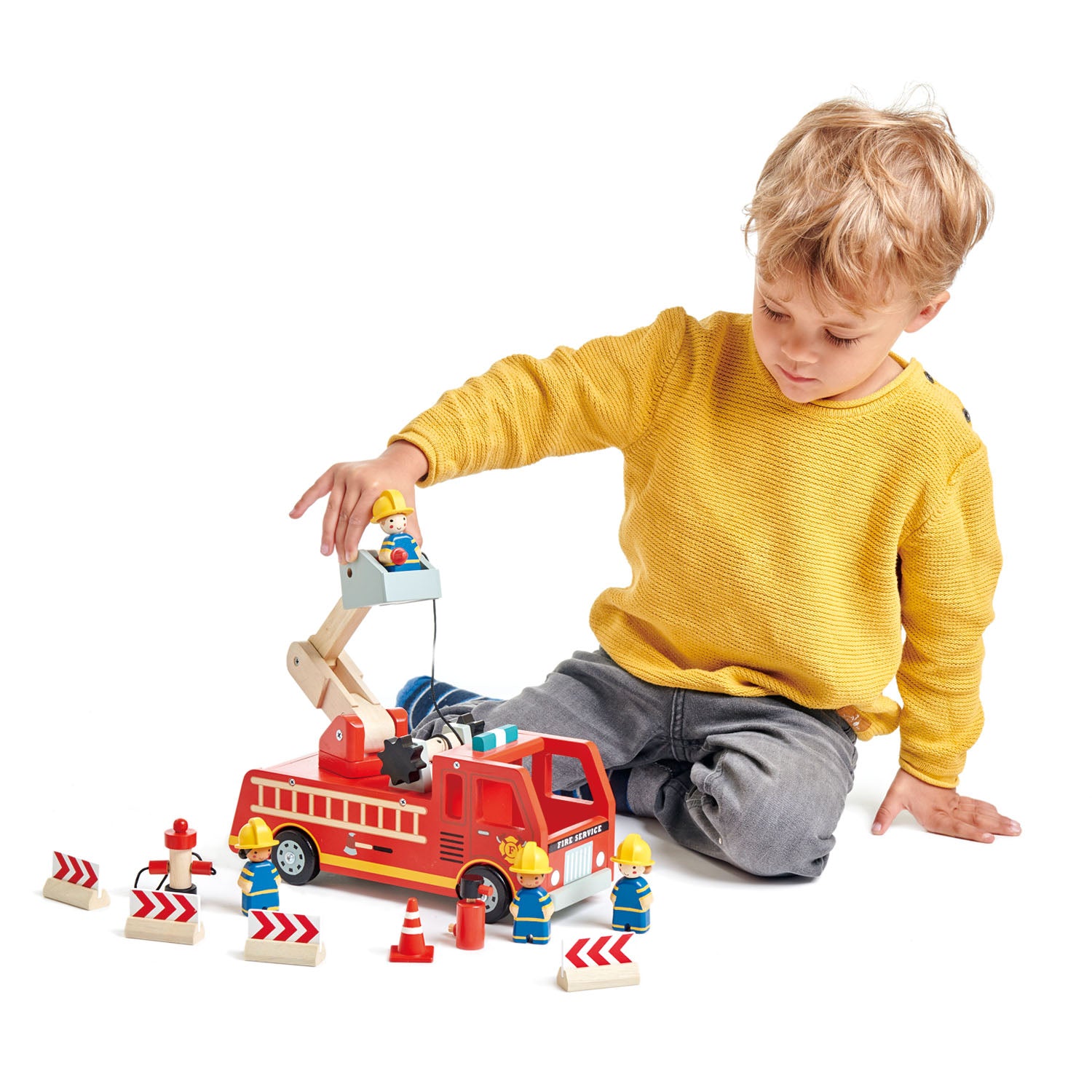 Boy playing with wooden fire engine set