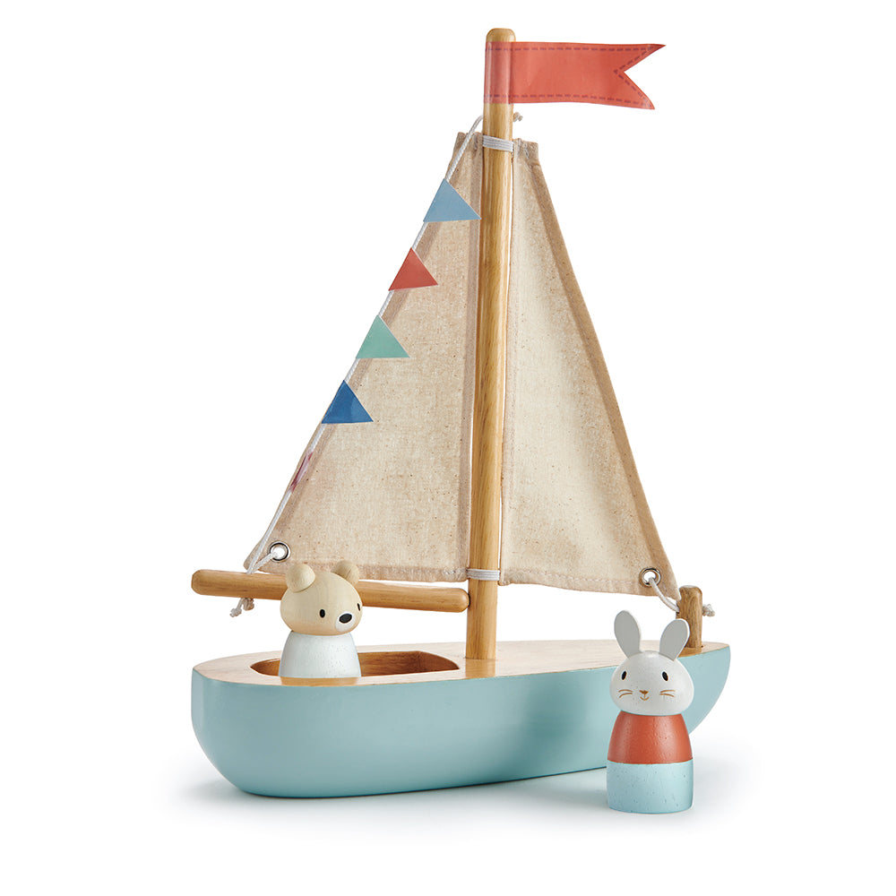 Bunny figurine standing next to wooden sail away boat with bear figurine standing inside the boat