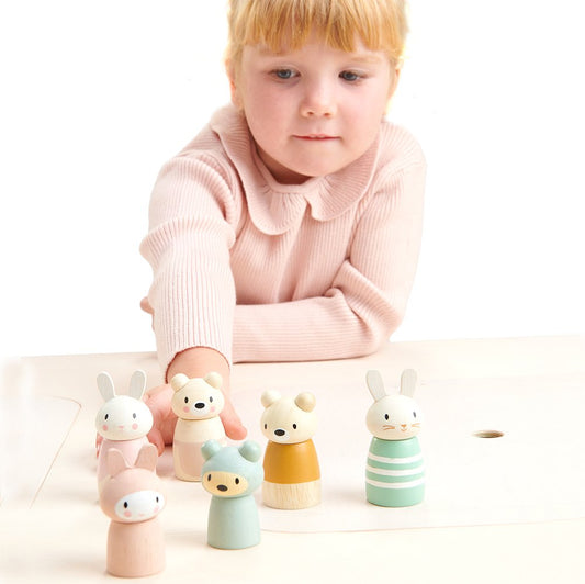 Girl playing with wooden bunny family