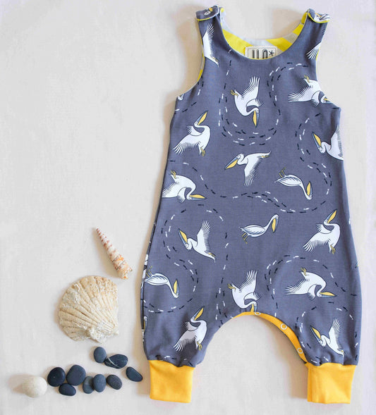 Pelican organic romper displayed next to shells and pebbles